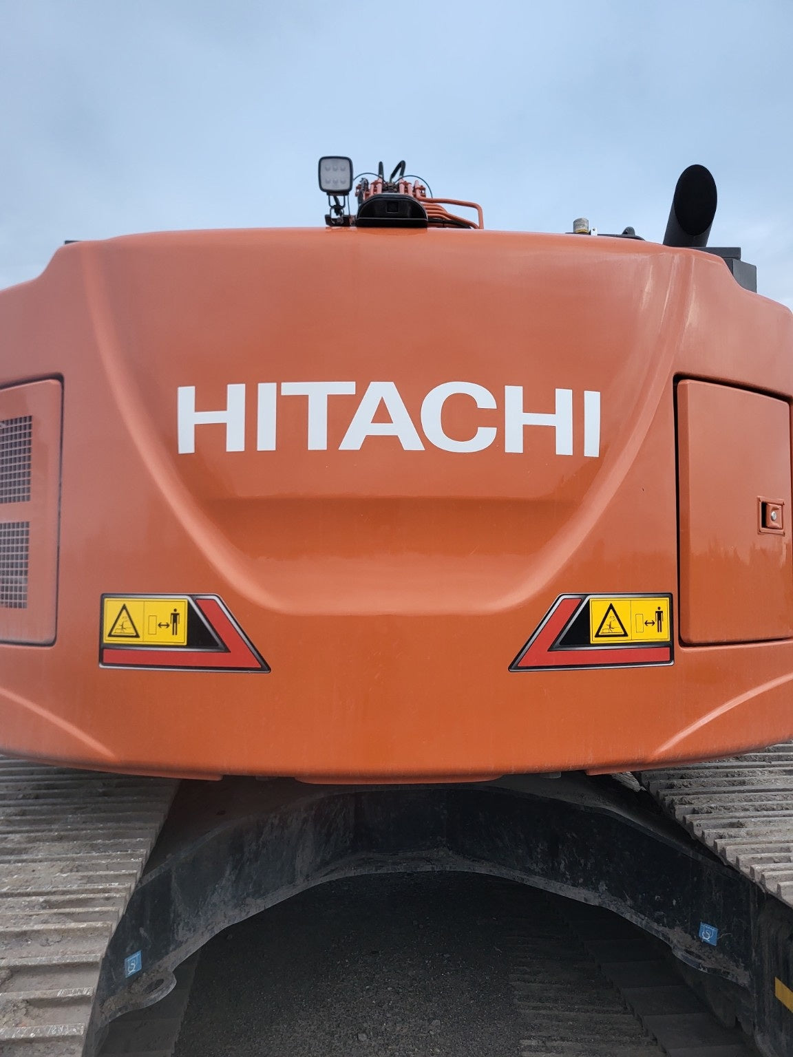 صورة مقربة لحروف HITACHI وملصقات السلامة الخلفية